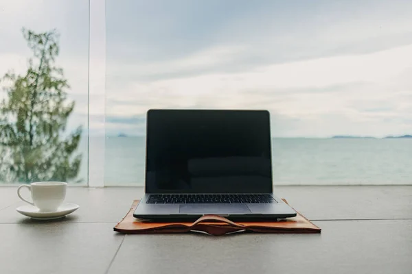 Laptop und Tasse Kaffee auf Hotelbalkon mit Meerblick. Arbeit aus dem Hotel. — Stockfoto