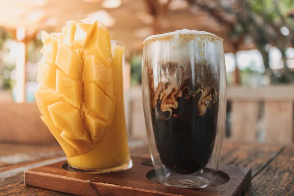 Bebidas heladas de café con leche y jugo de mango en concepto de verano. —  Fotos de Stock