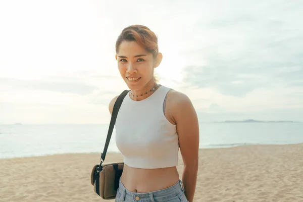 Gelukkig vrouw toerist wandelen rond het strand in de zomer. — Stockfoto