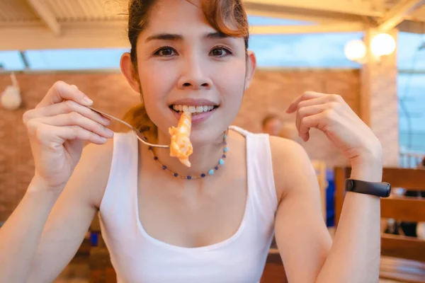 Mulher feliz gosta de comer frutos do mar lulas nas férias de verão. — Fotografia de Stock
