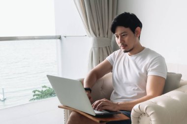 Kanepede mutlu, deniz manzaralı ve çalışkan. Konsept konaklama.