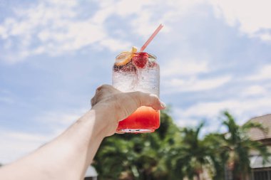 Yazın güneşli gökyüzüne karşı karışık meyveli pembe İtalyan gazozu.