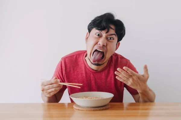 Faccia divertente dell'uomo mangiare molto caldo e piccante tagliatella istantanea. — Foto Stock