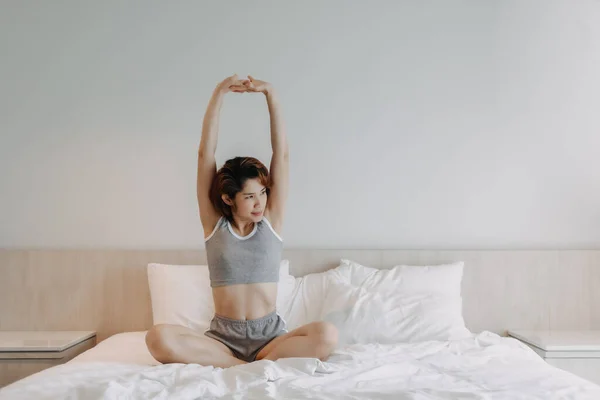 Aantrekkelijke vrouw in ondergoed stretching op het bed in de ochtend. — Stockfoto