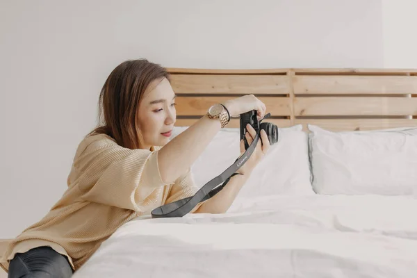 Fotógrafa revisando el visor de cámara en su propio apartamento. —  Fotos de Stock