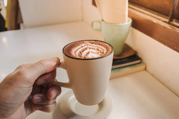 Kopi latte panas disajikan dalam cangkir putih di atas meja di pagi hari. — Stok Foto