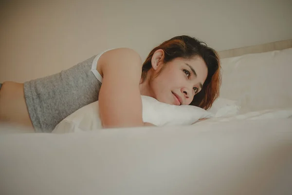 Attractive woman is lying in bed on summer morning. — Stock Photo, Image