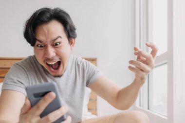 Şok olmuş ve mutlu bir adam akıllı telefondan iyi haberler alıyor..