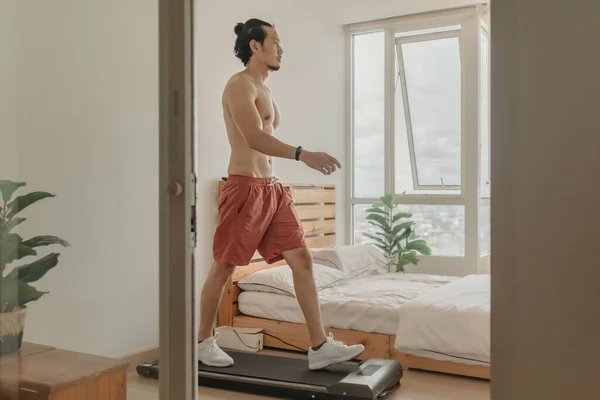 Manusia berolahraga dengan berjalan di atas treadmill di apartemennya. — Stok Foto