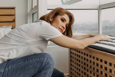 Havalı bir kadın dinleniyor ve evinden manzarayı seyrediyor..