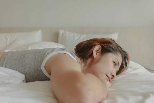Mujer atractiva yacía en la cama sensación de relax y acogedor por la mañana — Foto de Stock