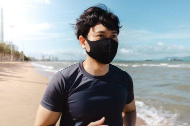 Adam yaz sabahı plajda maskeyle koşuyor..