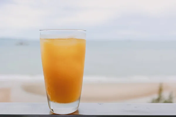 Saft im Glas mit Meerblick Hintergrund im Konzept des Sommers. — Stockfoto
