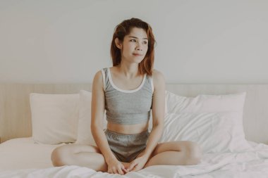 Çekici kadın yatak odasında uyandıktan sonra rahatlıyor. Yaz tatili.