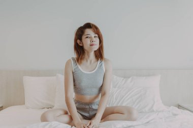 Çekici kadın yatak odasında uyandıktan sonra rahatlıyor. Yaz tatili.