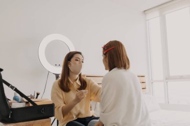 Makyajcı kadın işte ve modeline makyaj yapıyor..