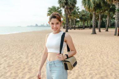 Mutlu kadın gülüyor ve sahilde yürüyor..