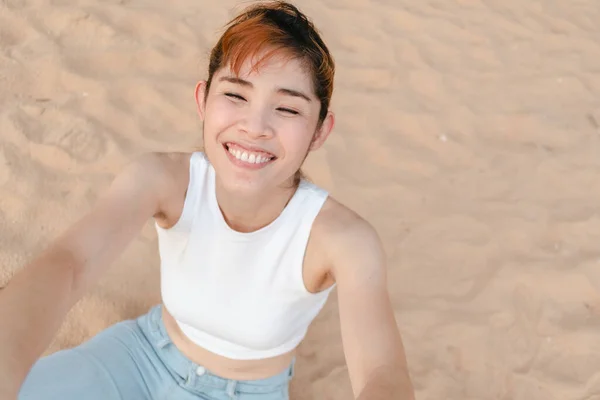 Vrouw zit op het strand in de zomer. — Stockfoto