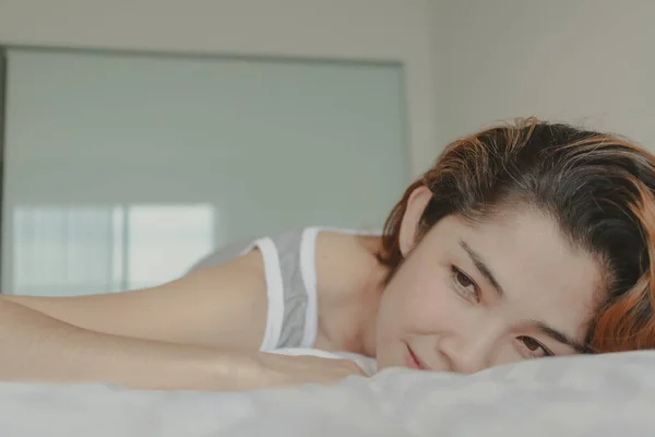 Aantrekkelijke vrouw lag op het bed gevoel ontspannen en gezellig in de ochtend — Stockfoto