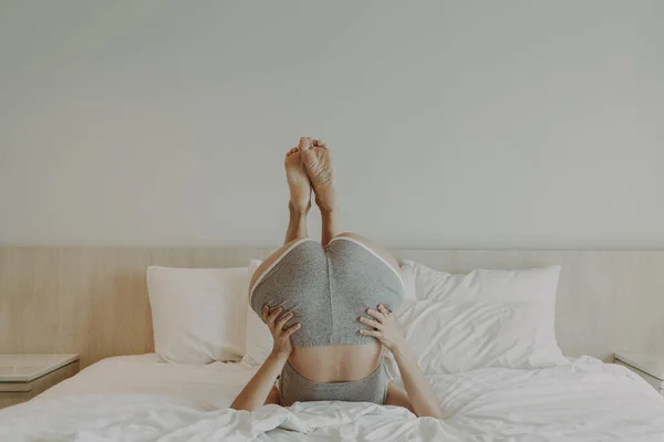 Oyuncu kadın yatakta baş aşağı poz veriyor.. — Stok fotoğraf