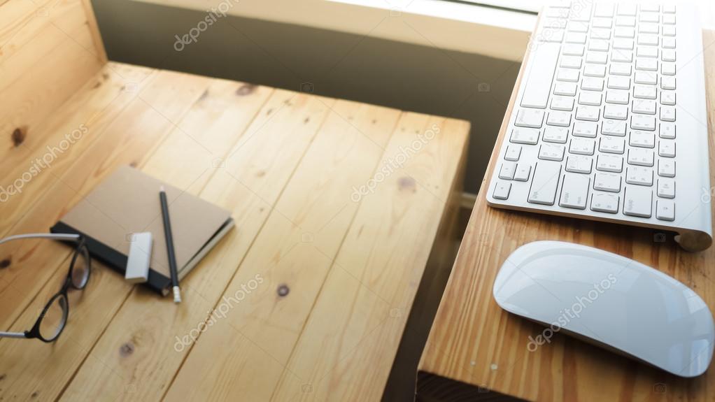 Loft workspace with stationaries on wooden table.