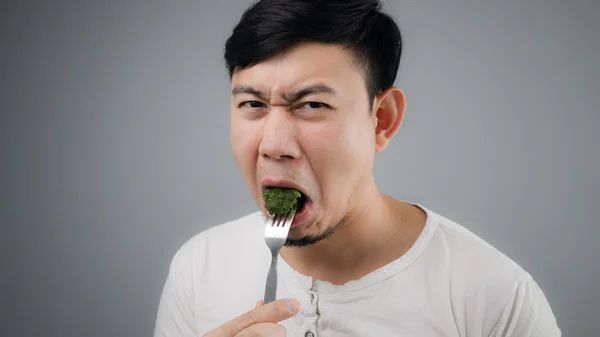 Un homme asiatique mange du brocoli . — Photo
