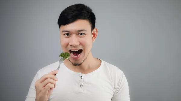 Asyalı bir adam brokoli yiyor. — Stok fotoğraf