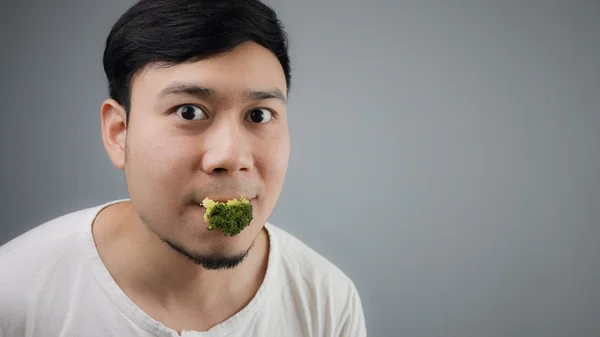 Un uomo asiatico mangia broccoli . — Foto Stock