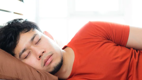 Asiatische Mann schlafen auf Bett. — Stockfoto