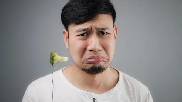 Un uomo asiatico mangia broccoli . — Foto Stock