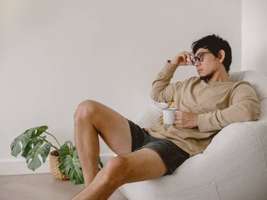 Bireysel olarak, rahat hisseden, kahvesini yudumlarken düşünceli bir şekilde kapalı bir alanda oturmaktan zevk alan, yansıtan