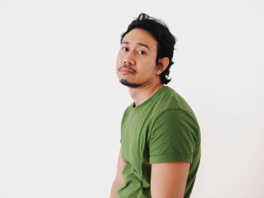 Sıkılmış ve depresif Asyalı yeşil tişörtlü adam beyazda izole edilmiş. Yüksek kalite fotoğraf