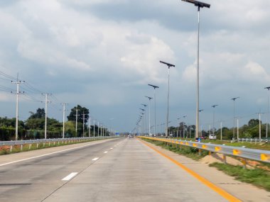 Çevre dostu, güneşli sokak lambaları ve canlı yeşilliklerle dolu güzel ve manzaralı bir otoyol.