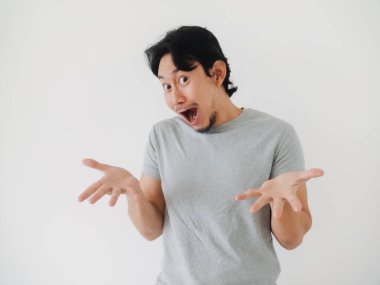 Şaşırmış ve heyecanlı görünen bir adam, ellerini beyaz bir zemine doğru hareketlendiriyor.