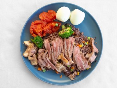 Dilimlenmiş ördek brokoli ve haşlanmış yumurta ile karışık tahıllı pirinç, aktif yaşam tarzı için protein paketlenmiş yemek tabağı, gevrek.