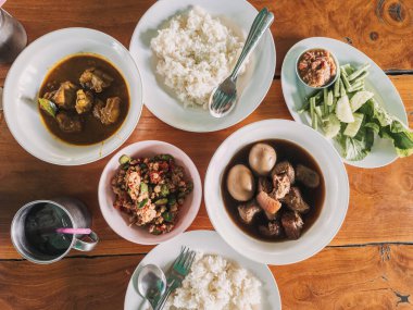 Tayland halk yemeği, pirinç kaseleriyle sıcak ahşap masa seramik kaseler baharatlı et çorbası köftesi, yasemin, pirinç, acı biber.