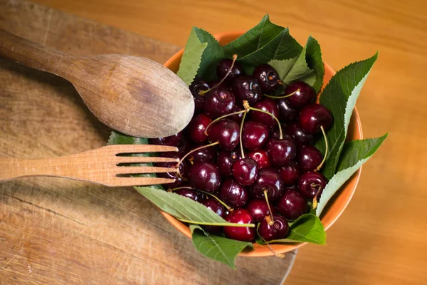 Mogna körsbär i skål med gaffel och sked — Stockfoto