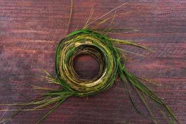 Çelenk ahşap bir masa üzerinde yeşil otlar