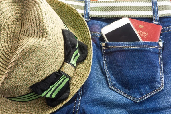 Passort and mobile in blue jeans pocket means  journey