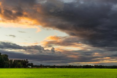 Kara bulutlar dramatik ton alanıyla gün batımında