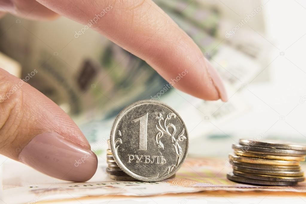 Hand takes the ruble and dollars with banks of rubles