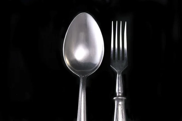 Cuchara y tenedor sobre un terciopelo negro — Foto de Stock