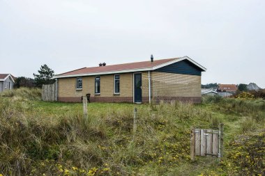 Sonbaharda Vlieland 'daki Teh Wadden Adası' nın kumullarındaki doğa bölgesinde bir tatil evi.