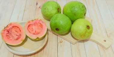 Guava, büyük miktarda guava meyvesi. Taze guava meyvesi. Tahtada guava dilimleri