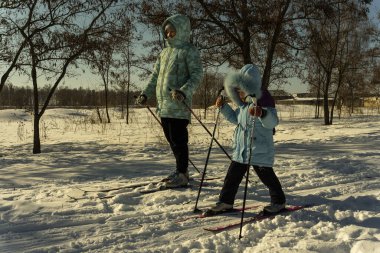 Kış günü bir ebeveyn çocuğuyla kayak yapmaya gider.