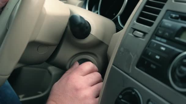 Манская рука кладет ключ от машины в отверстие для ключа, запуская машину. — стоковое видео