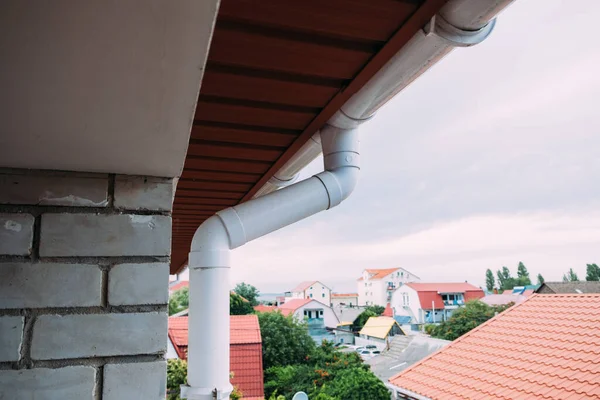 White plastic downpipe on the roof of the cottage. — Stock Photo, Image