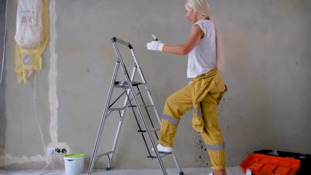 ブロンドの電気技師の少女は電気配線で修理作業を行うために階段を登る 家の中に電気を設置するコンセプト — ストック動画
