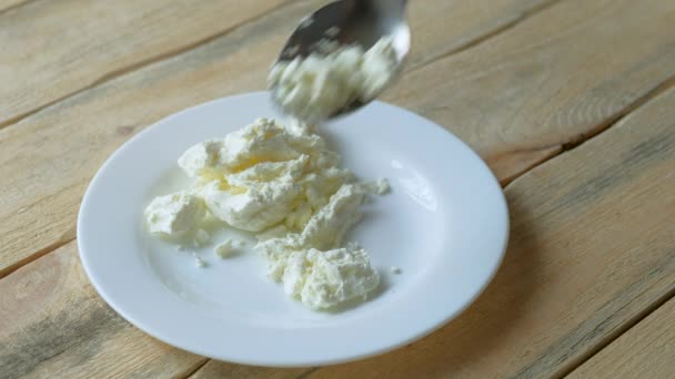 Hüttenkäse Mit Einem Metalllöffel Auf Einem Tisch Aus Hellen Holzbrettern — Stockvideo