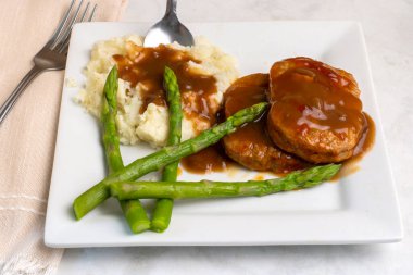 salisbury steak  served with mashed potatoes and  asparagus